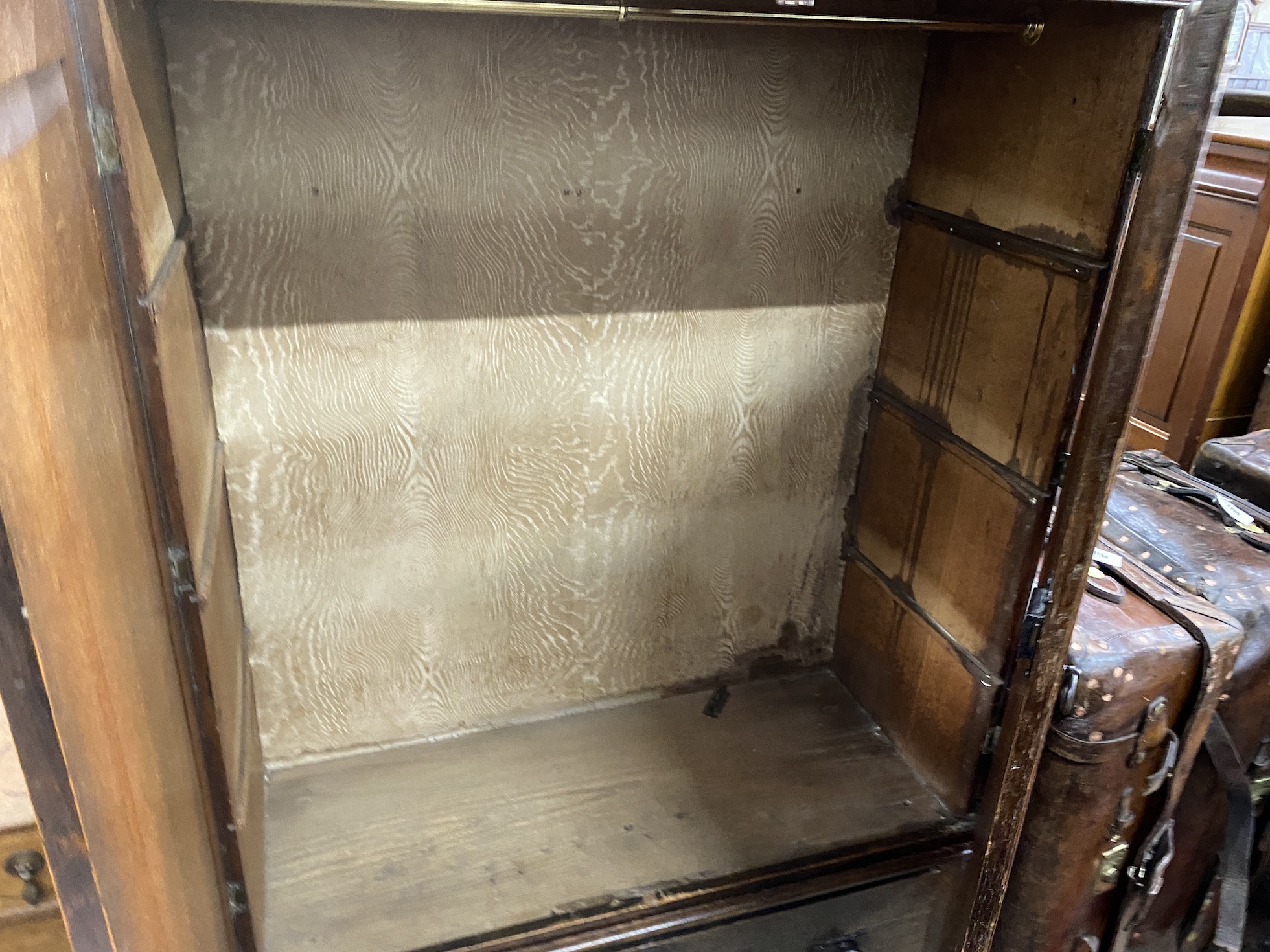 A late 18th century oak hanging cupboard, with later Art Nouveau hammered copper hinges, width 116cm, depth 50cm, height 173cm